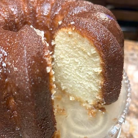 Close-up of the butter-glazed crust and tender white crumb of a freshly cut pound cake